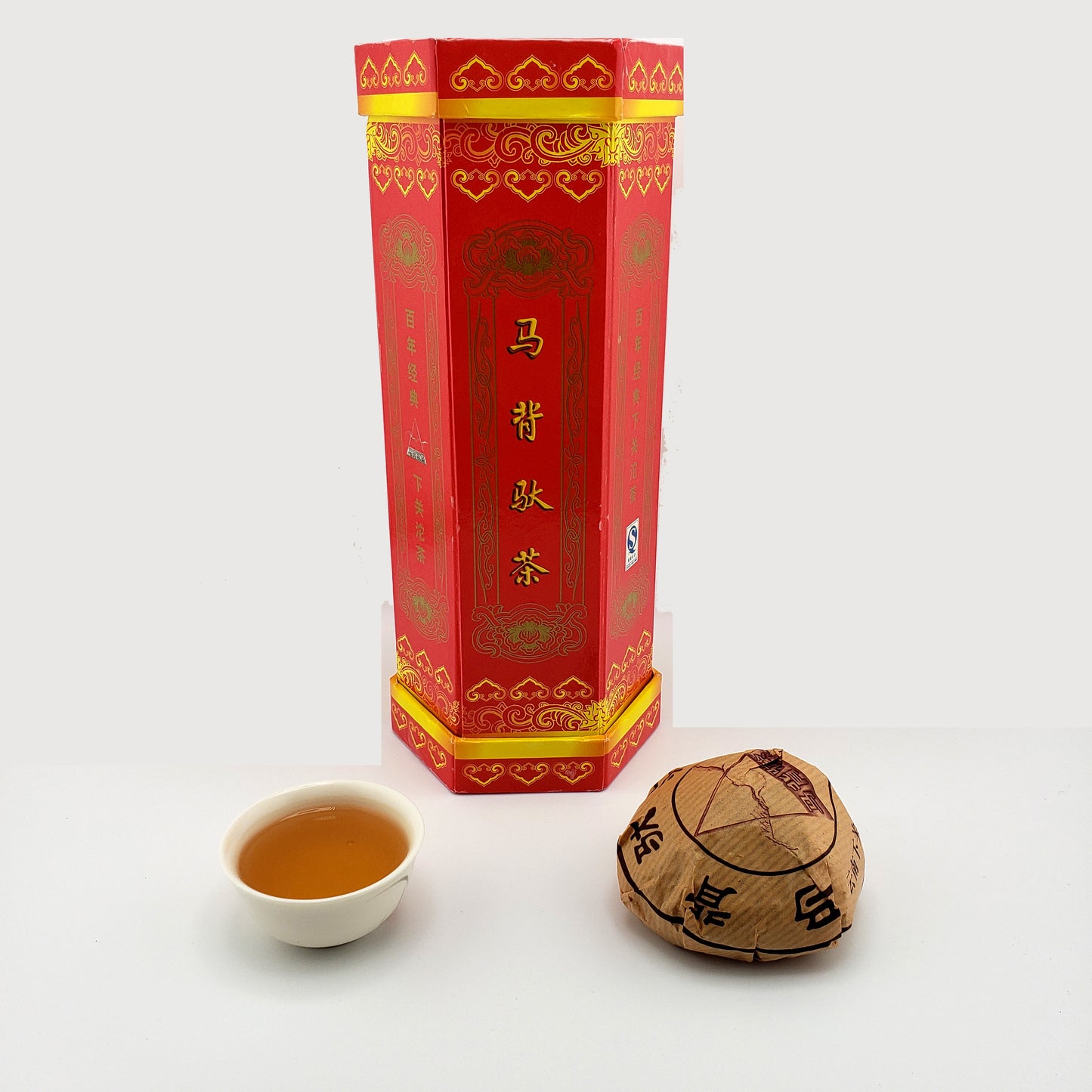 Display pack of 5 tuo cha, one tuo cha raw pu-erh tea and a cup of brewed tea.