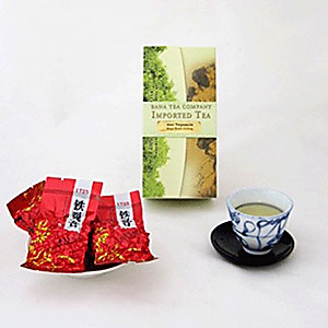 Red tea packages, green tea box, and a cup of green tea on a white background