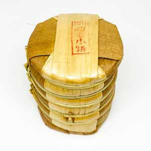 Tong of tea cakes in bamboo leaf package