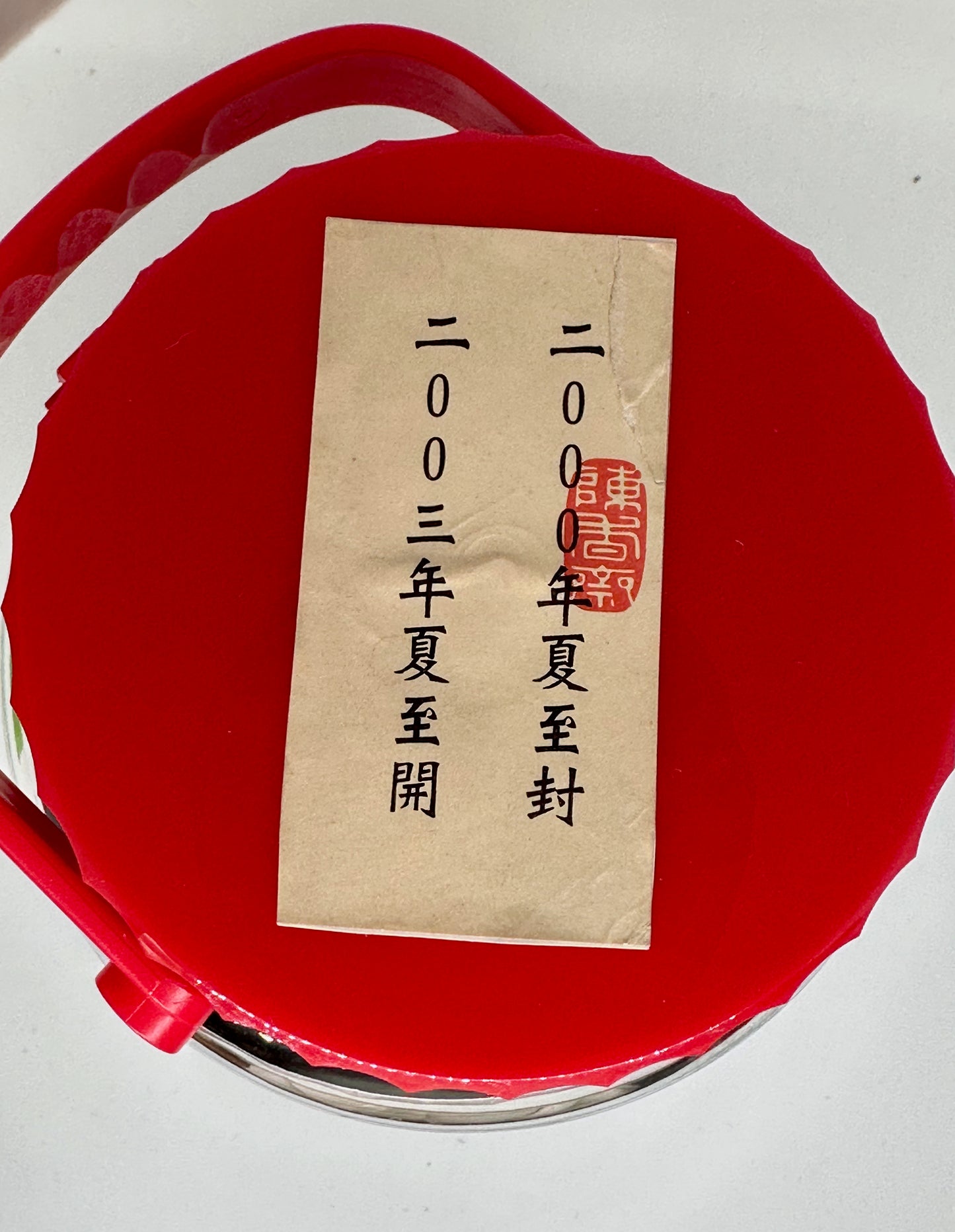 Red seal with a label featuring text and a stamp on a white background
