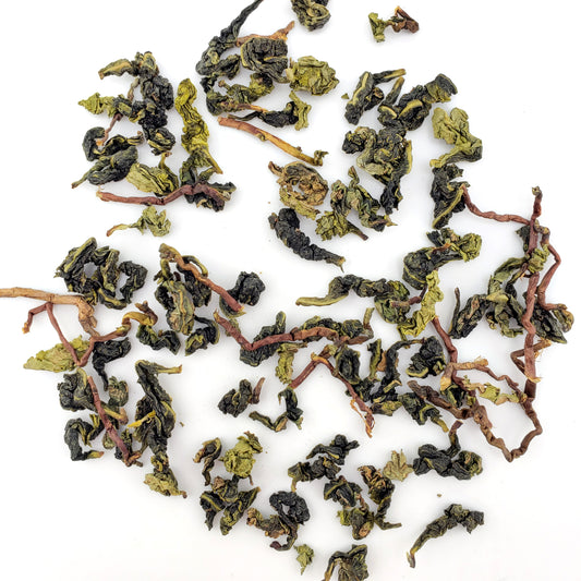 Dried green tea leaves on a white background