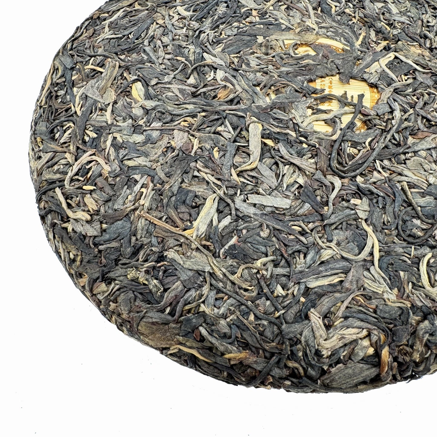 Round cake of compressed tea leaves on a light blue background