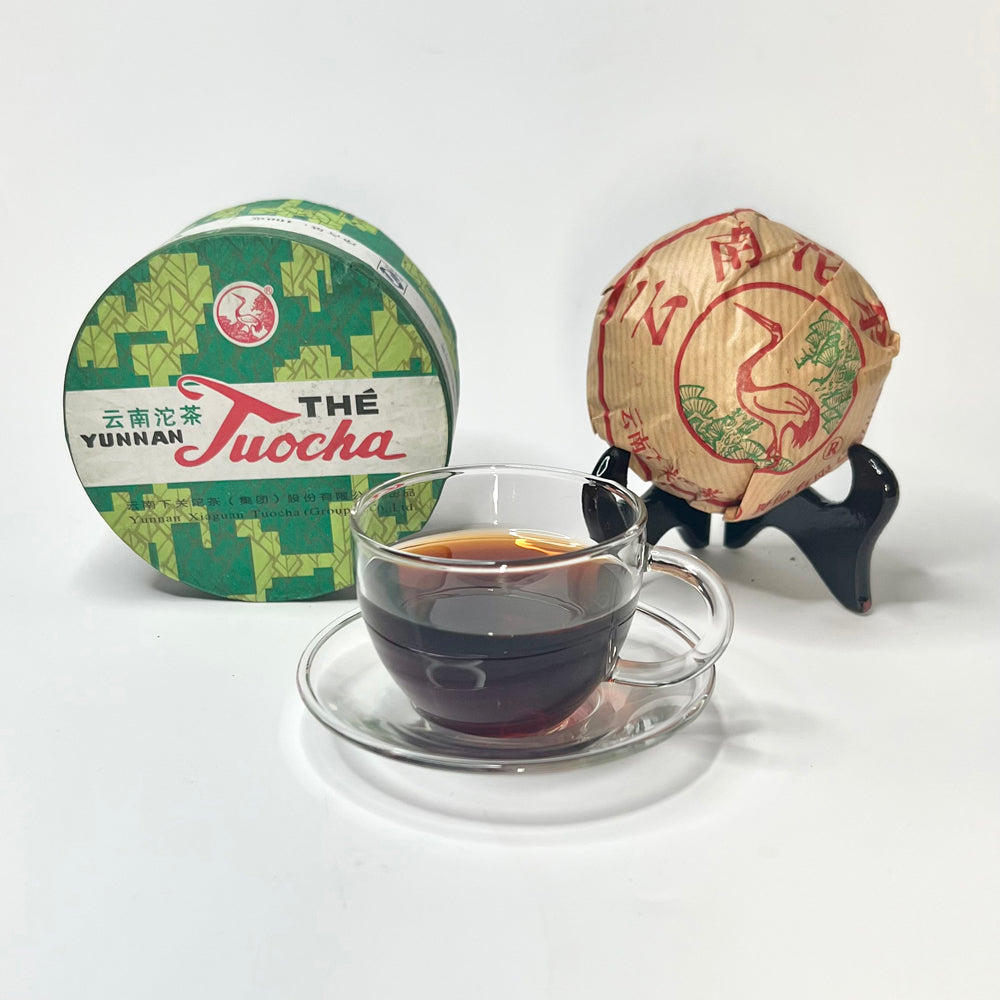 Yunnan Pu'Er tea cake with a cup of tea on a white background