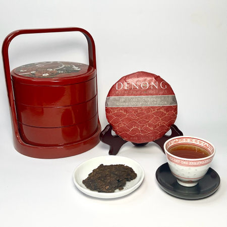 Tea cake with a cup of tea and tea leaves on a white background