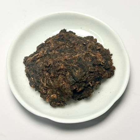 Dark brown fermented tea cake on a white plate