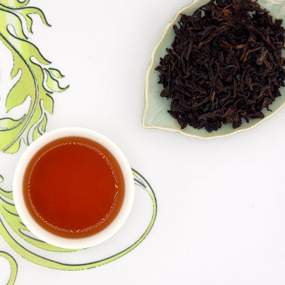 Dry tea leaves and a cup of brewed tea