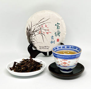 Tea packaging with a cup of tea and loose tea leaves on a white background