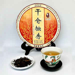 Tea cake with a decorative label and a teacup on a white background