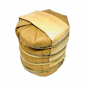 Tong of tea cakes in bamboo leaf package