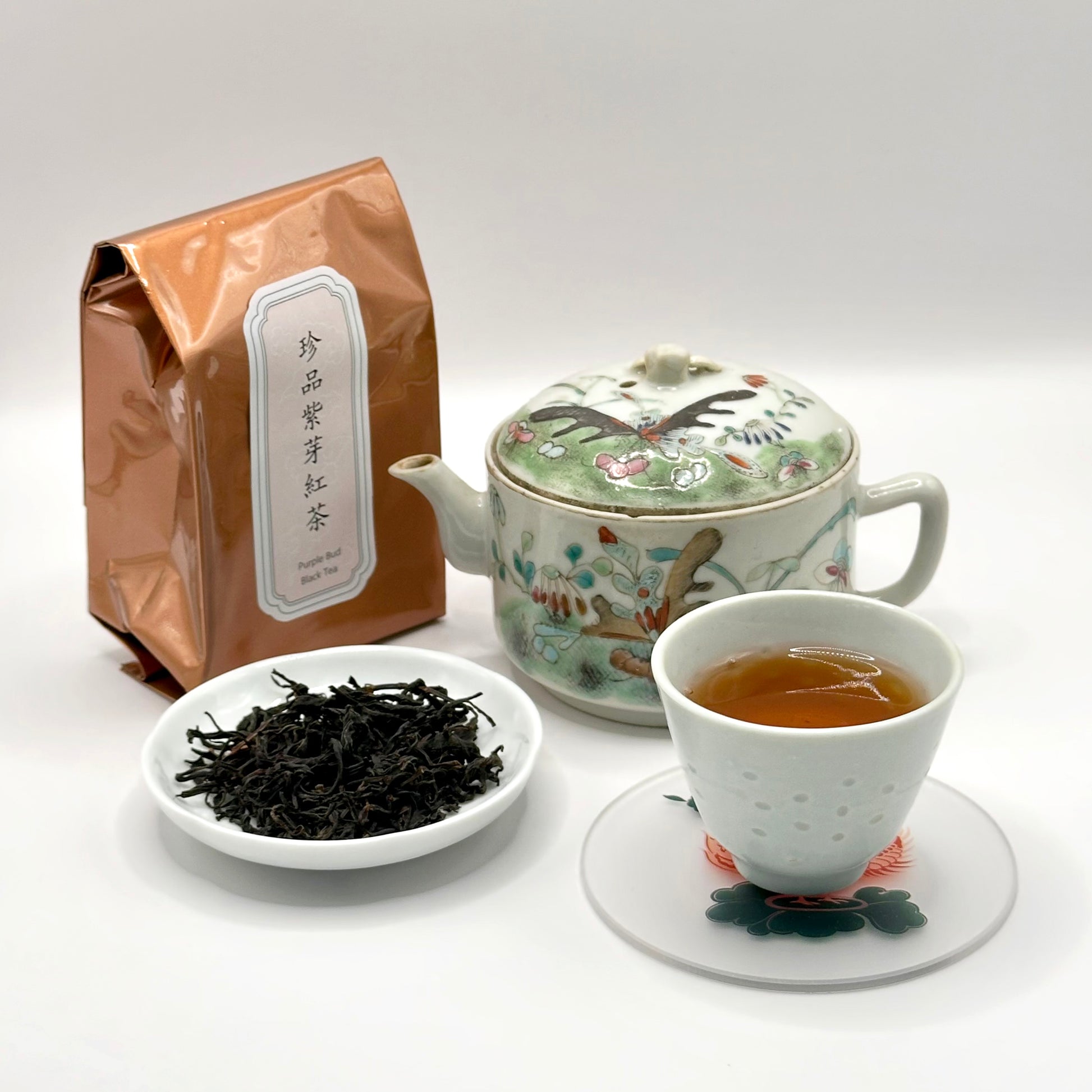 Tea set with a bag, teapot, cup, and bowl of tea leaves on a white background