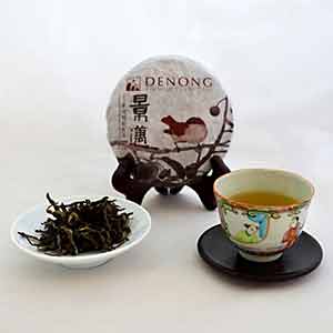 Tea packaging, loose tea leaves, and a cup of tea on a white background