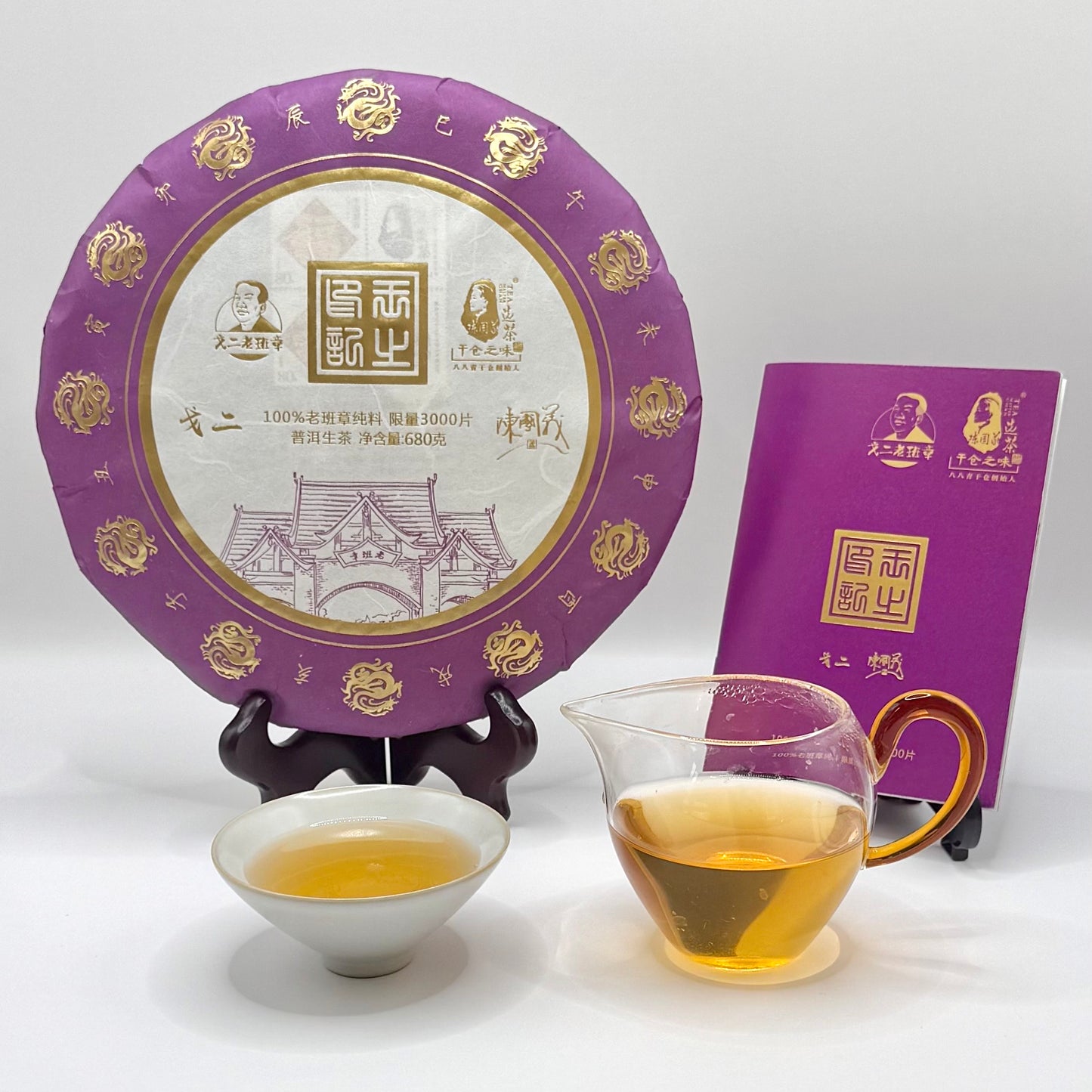Tea cake with purple packaging, a glass of tea, and a small bowl on a white background