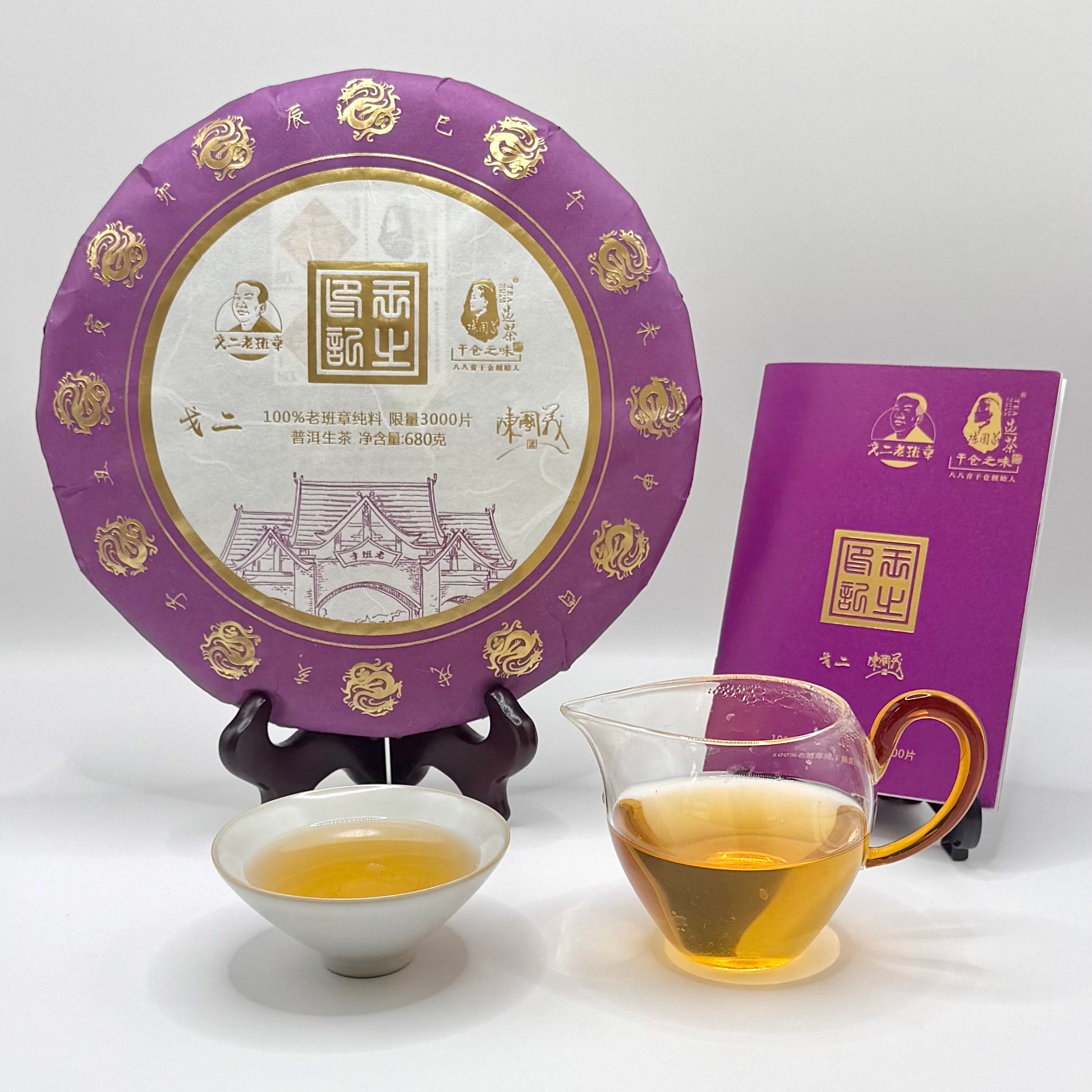 Tea cake with purple packaging, a glass of tea, and a small bowl on a white background