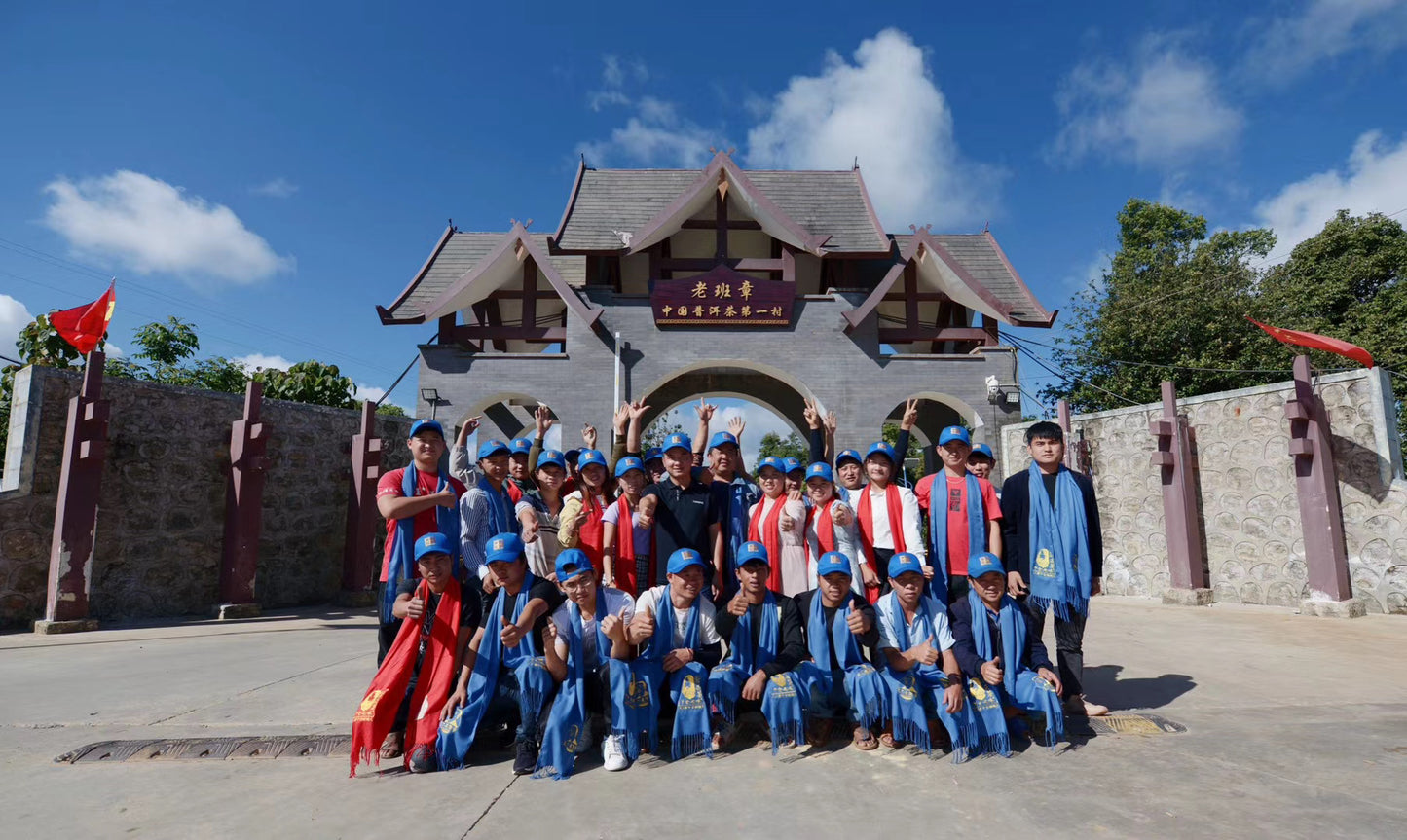 Group of people posing in front of a traditional-style building with a blue sky.