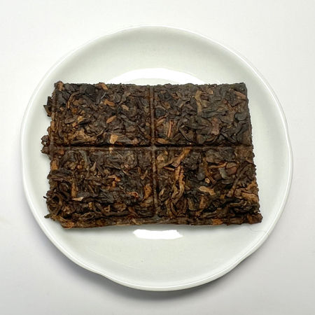 Square pieces of dark brown tea on a white plate