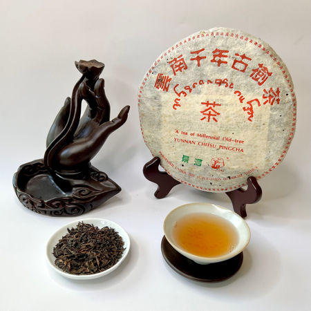 Tea packaging, tea leaves, and a cup of tea on a white background