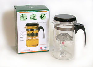 Clear glass mug with black handle and lid on a white background