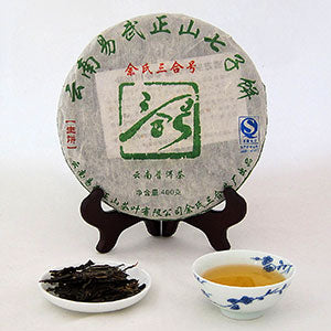 Tea cake with a stand, tea leaves, and a cup of tea on a white background