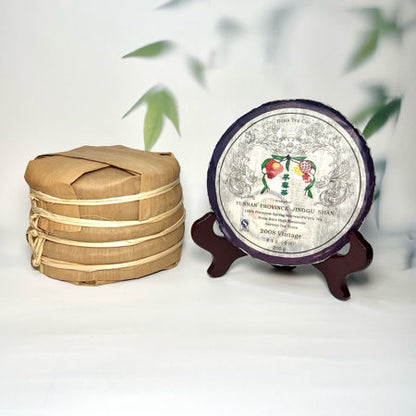 Traditional woven bamboo container and decorative tea cake with floral design on a white background