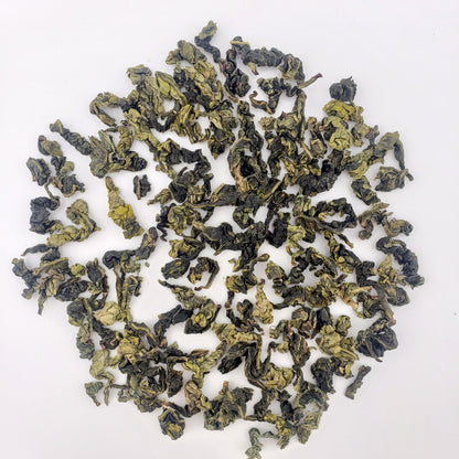 Dry green tea leaves on a white background