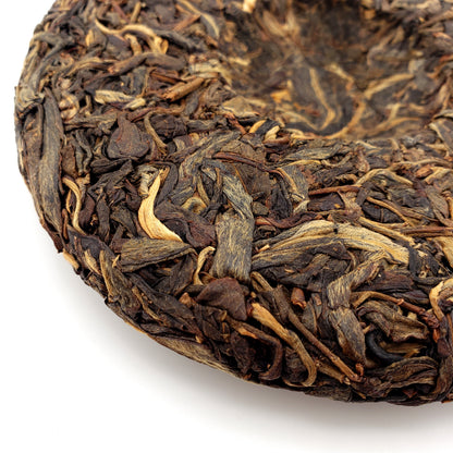 Close-up of pressed Pu-erh tea cake on a white background