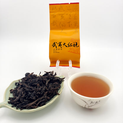 Tea packaging, cup of tea, and tea leaves on a white background