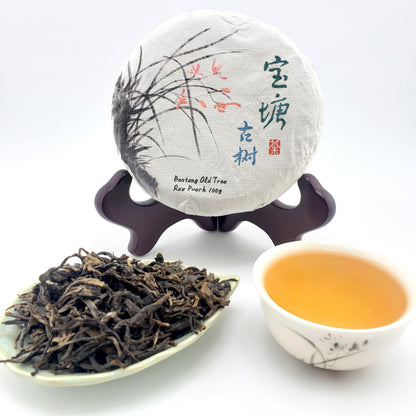 Tea packaging, tea leaves, and a cup of tea on a white background