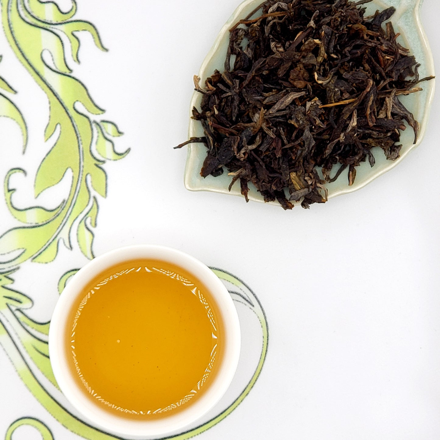 Dry tea leaves and a cup of brewed tea