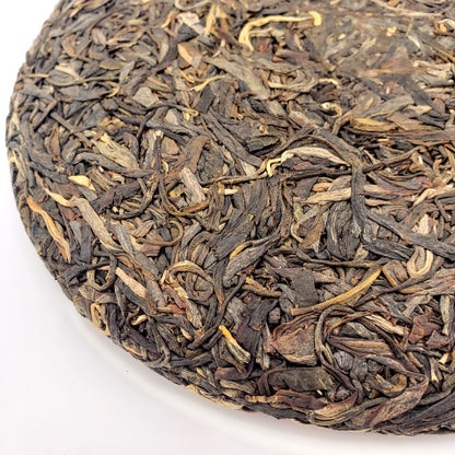 Close-up of a pressed Pu-erh tea cake on a white background