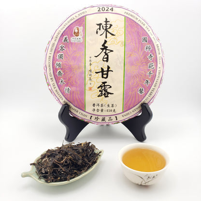 Tea cake with packaging, a tea scoop, and a cup of tea on a white background