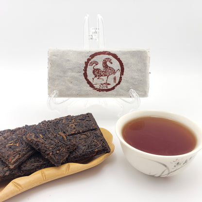 Tea packaging featuring a horse illustration, Pu-erh tea bricks, and a cup of tea on a white background