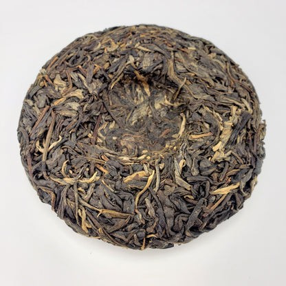 Pressed Pu-erh tea cake on a white background