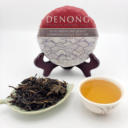 Denong tea cake packaging with a spoonful of tea leaves and a cup of tea on a white background
