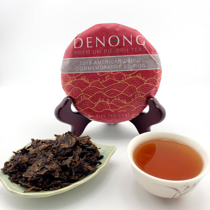 Denong tea cake with a cup of tea and tea leaves on a white background