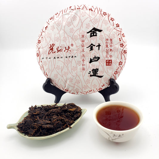 Tea cake, tea leaves, and a cup of tea on a white background with a decorative plate.