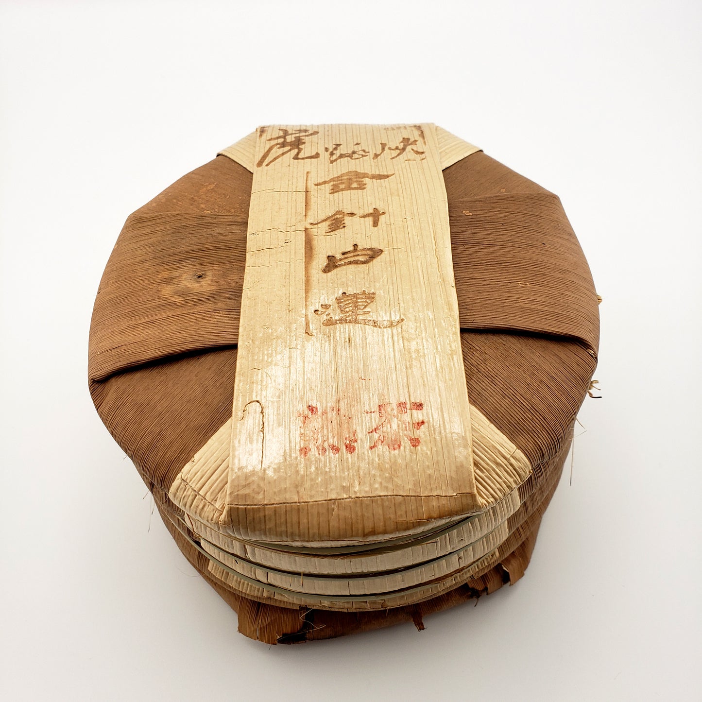 Tong of tea cakes in bamboo wrapping