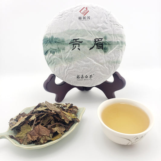 Tea cake, teacup with tea, and scoop of tea leaves on a white background