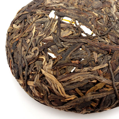 Close-up of a cake of compressed tea leaves on a white background