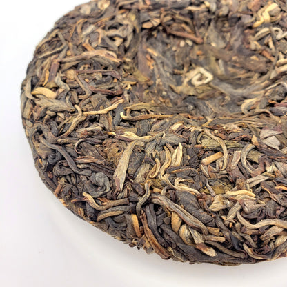 Close-up of a round cake of compressed tea leaves on a white background
