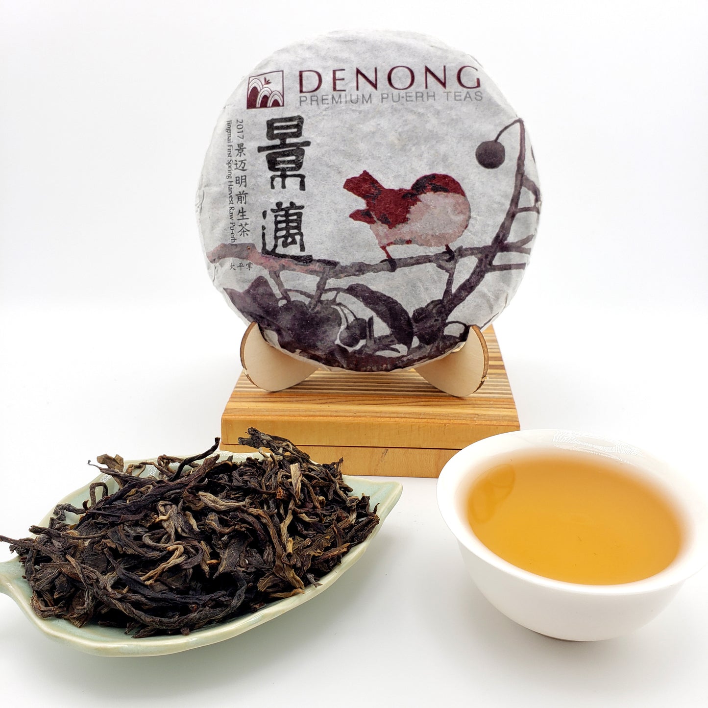 Tea packaging with a squirrel illustration, a cup of tea, and a bowl of loose tea leaves on a white background.