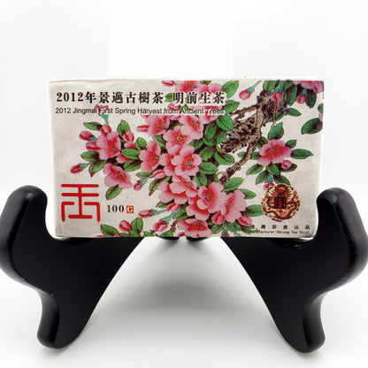 Tea packaging with floral design and text on a black stand