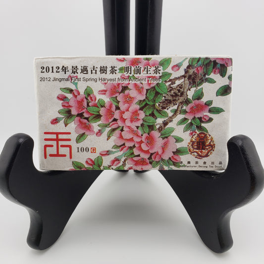 Tea packaging with floral design and text on a black stand