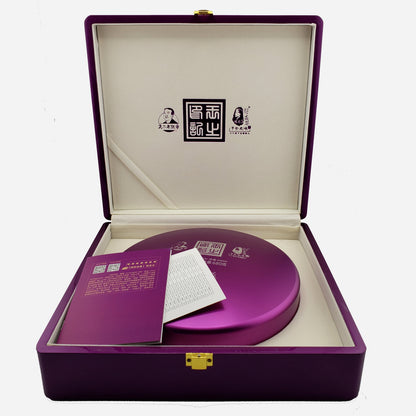 Purple jewel-toned box with a circular purple shell case inside on a white background