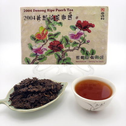 Tea packaging with floral design, a cup of tea, and a spoonful of tea leaves on a white background