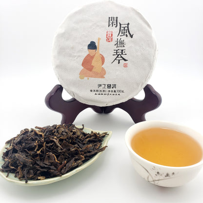 Tea packaging, cup of tea, and tea leaves on a white background