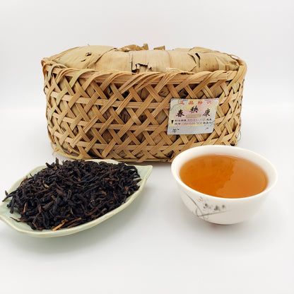 Woven basket of tea leaves with a cup of tea and a bowl of loose tea on a white background