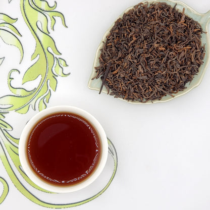 Tea leaves and a cup of tea on a decorative white and green background