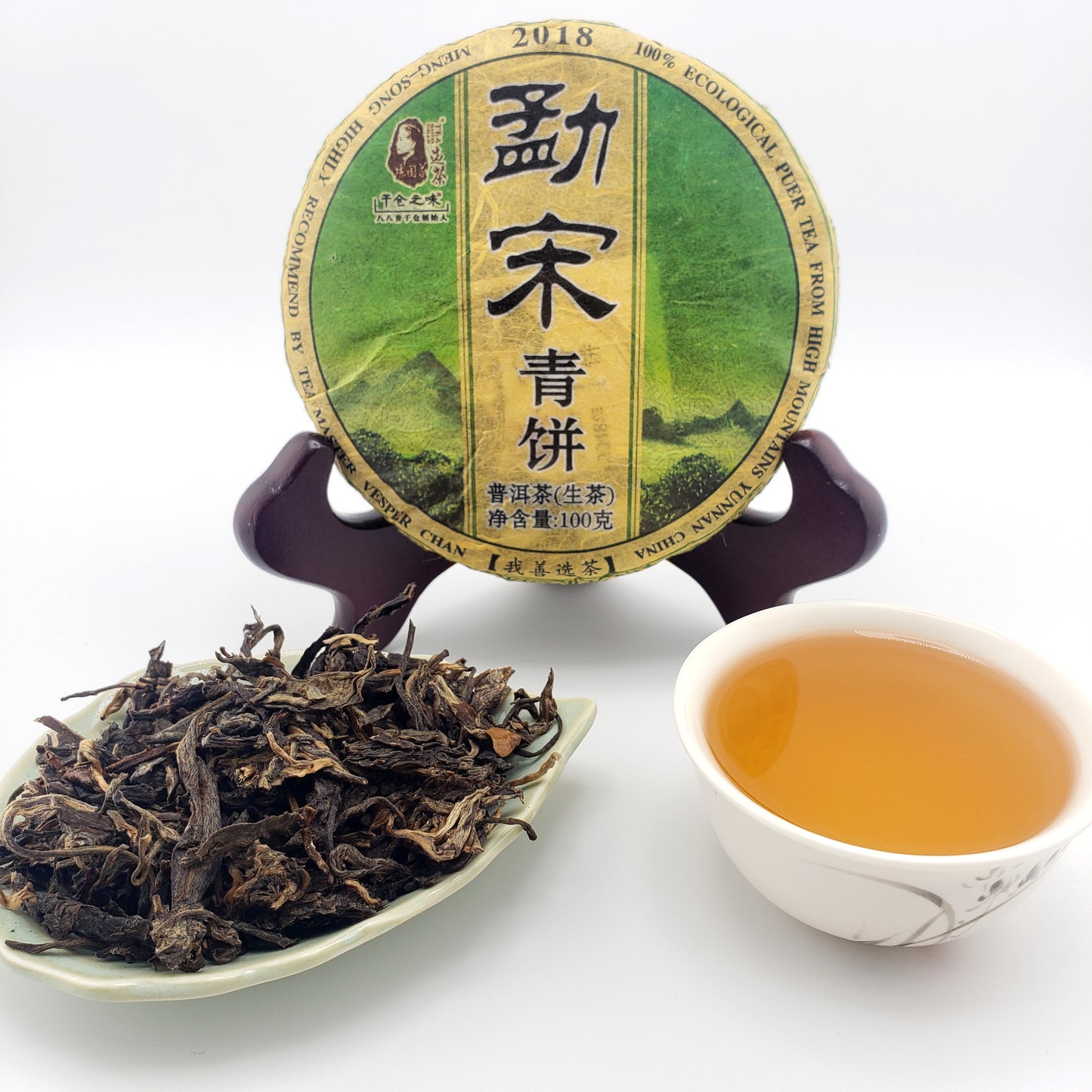 Tea packaging, cup of tea, and dry tea leaves on a white background