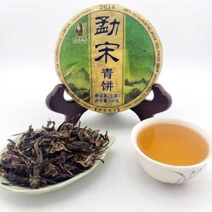 Tea packaging, cup of tea, and dry tea leaves on a white background