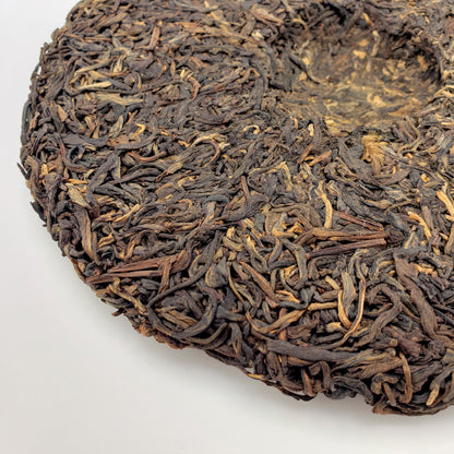 Close-up of dark brown tea leaves on a white background